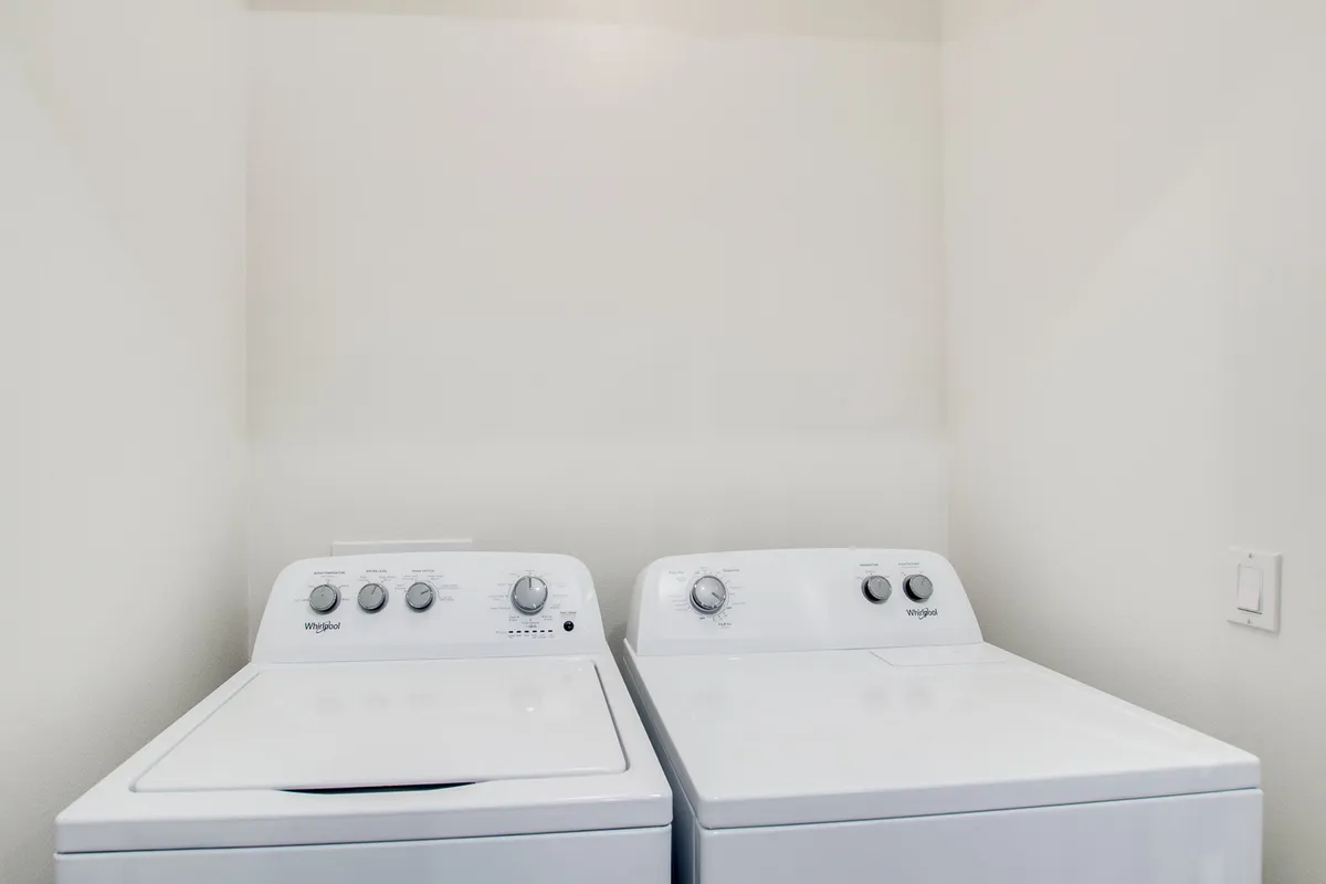 A practical laundry room setup with a washing machine and dryer, designed with functionality and convenience in mind. The space is clean and organized, supporting daily routines for longer or active stays.