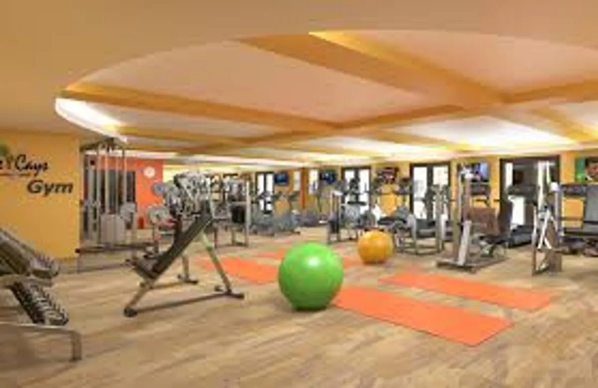 A modern fitness center with various exercise equipment, yoga mats, and fitness balls. The room is bright, airy, and designed for both group workouts and individual sessions.